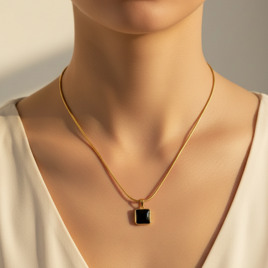 Gold snake chain black square pendant necklace worn around woman's neck lifestyle shot