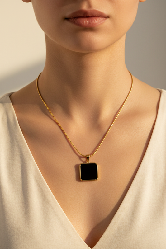 Gold snake chain black square pendant necklace worn around woman's neck lifestyle shot
