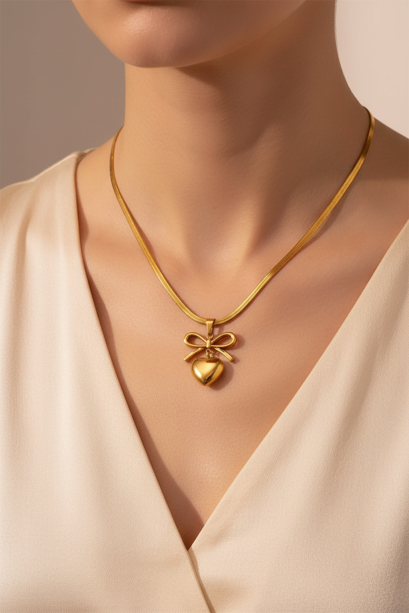 Gold bow heart pendant necklace worn around woman's neck lifestyle shot